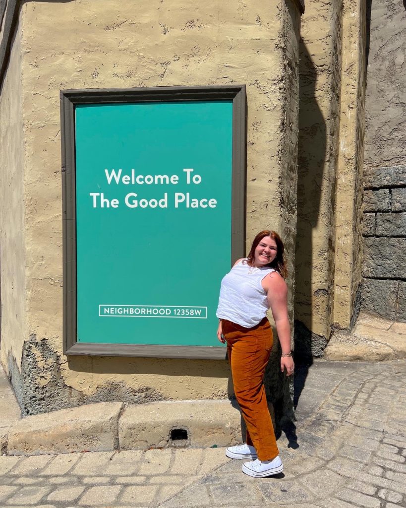 Adi Beckman posing next to a TV show sign while on her trip. 