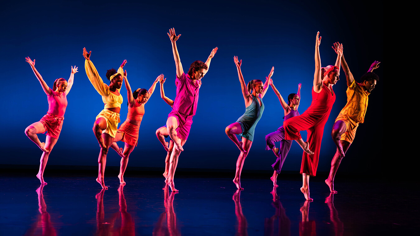 The School of Dance ensemble performs on stage in colorful costumes.